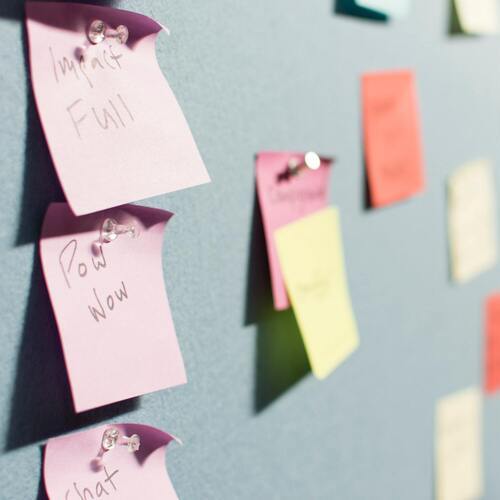Colorful post-its pinned and sticked to the grey wall